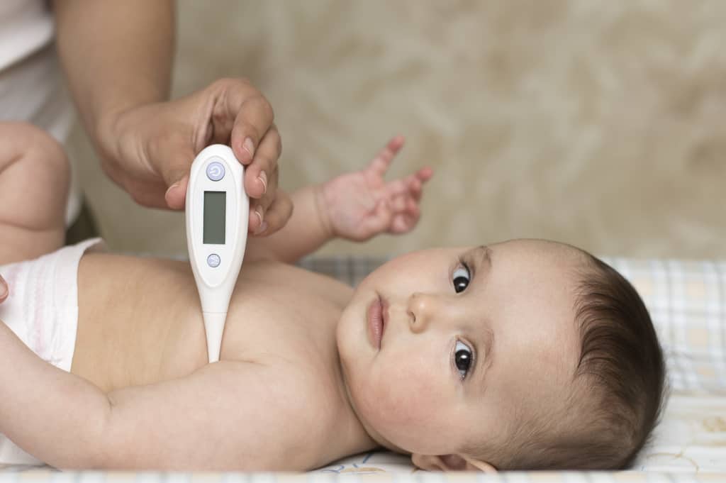 Baby mit Digitalfieberthermometer