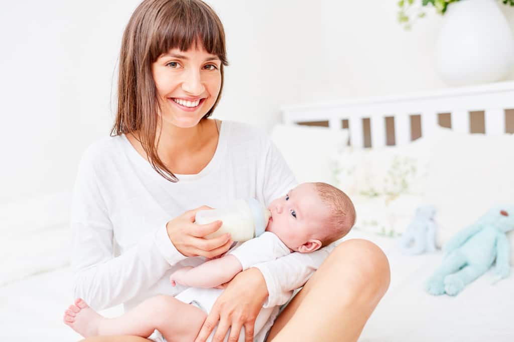 Babyflasche 48 Glückliche Mutter gibt ihrem Baby die Flasche