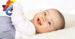 Ein Baby spielt mit einem Greifling