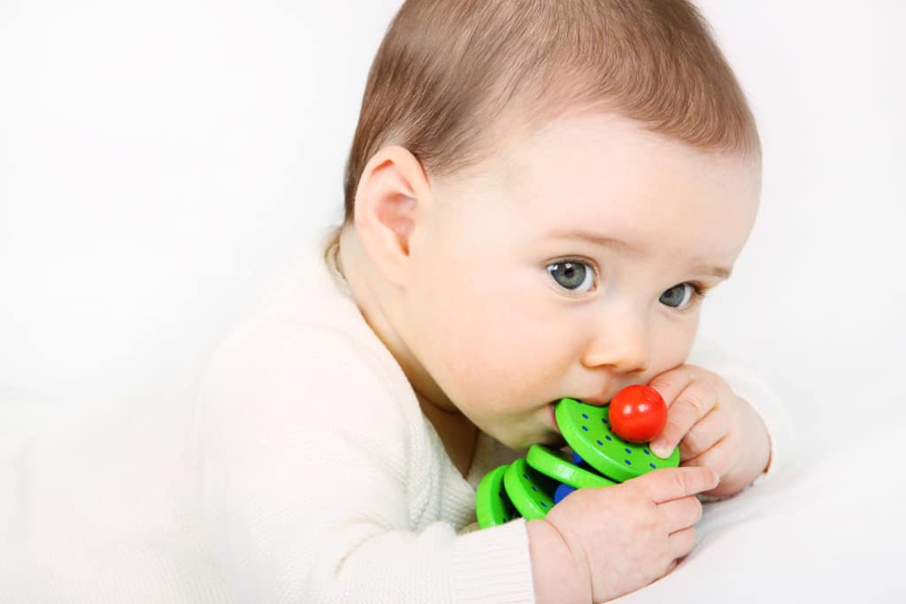 Greifling 42 Ein Baby spielt mit einem Greifling aus Holz